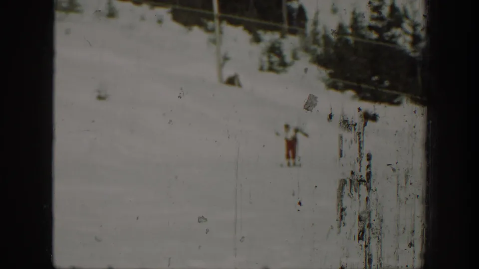 1940 Washington home-movie frame with a lone skier on snow, seen through a worn 8mm film frame.