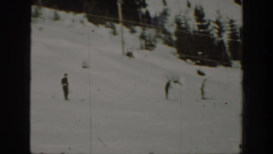 Several skiers appear scattered across a snow-covered Washington ski slope, with trees and possible lift cables in the background.