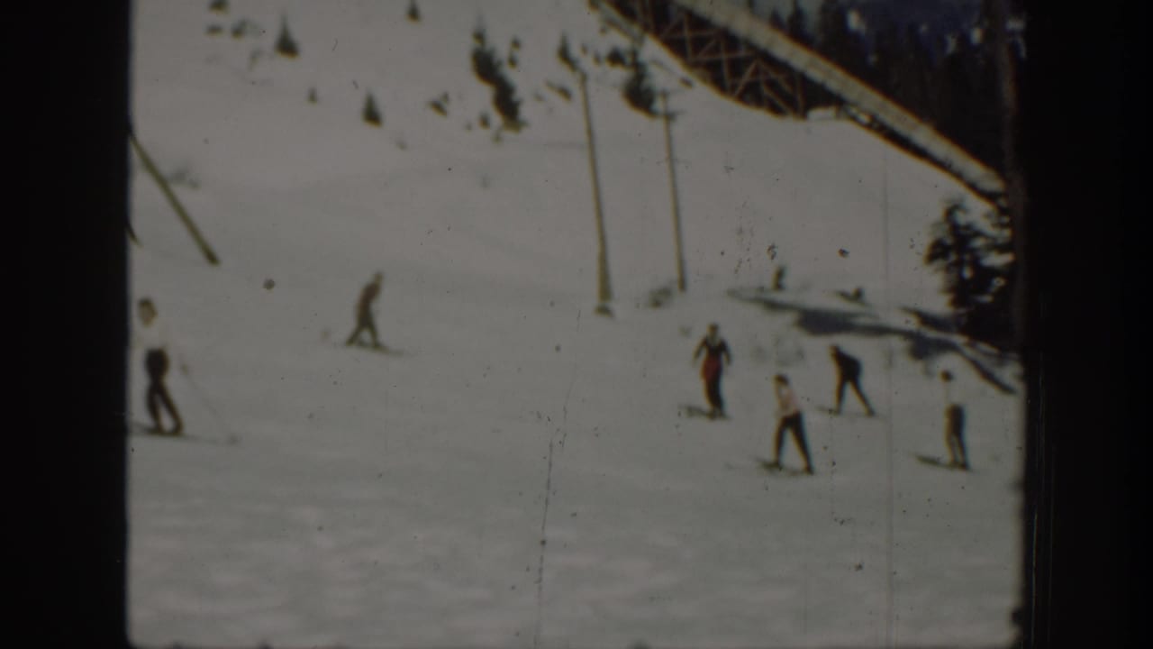 1940 Washington ski scene with several distant figures crossing snow near poles, evergreens, and a sloping overhead structure.