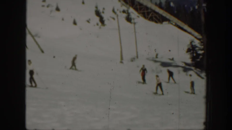 1940 Washington ski scene with several distant figures crossing snow near poles, evergreens, and a sloping overhead structure.