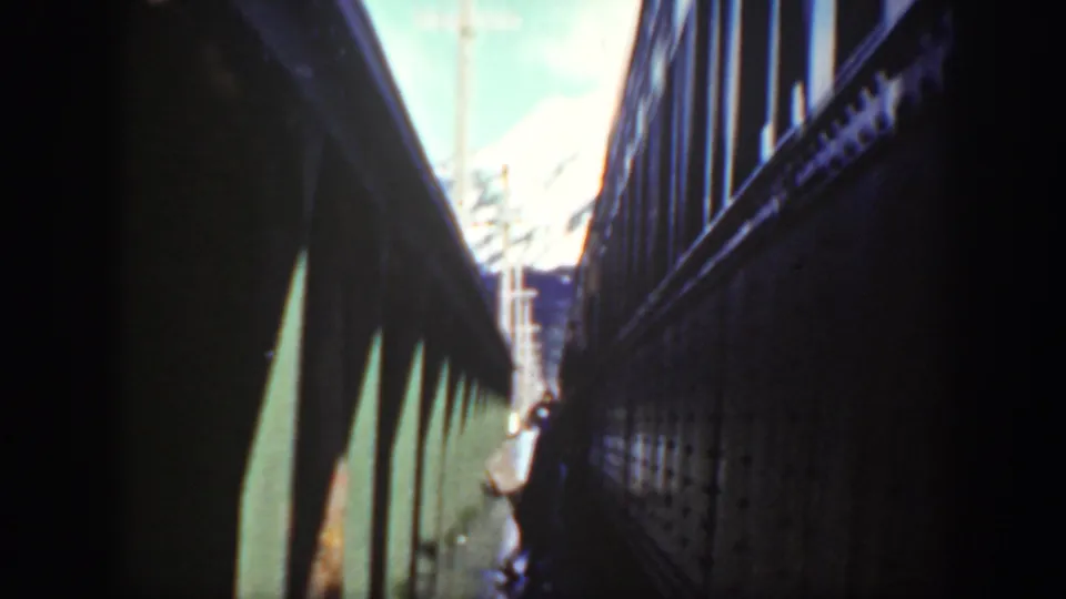 Washington 1940 home-movie frame looking along two train cars, with a passenger partly visible near the lower edge.
