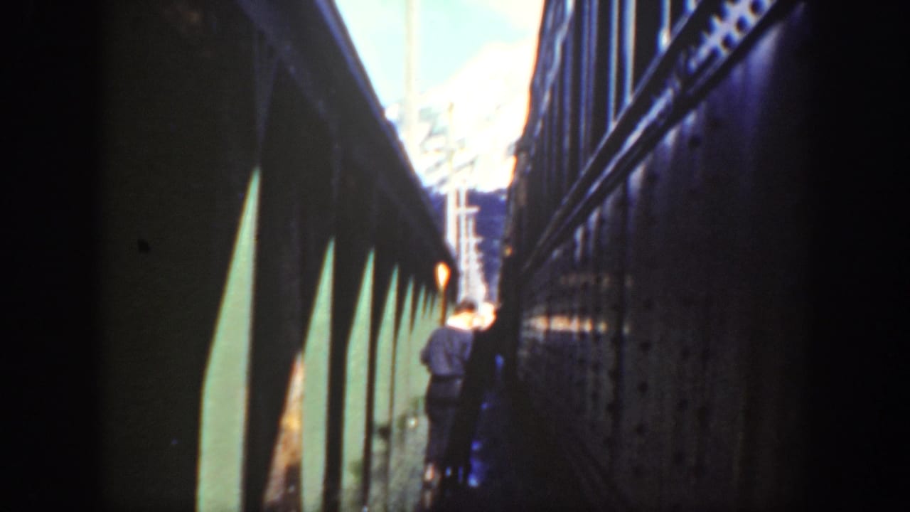 Washington 1940 home-movie frame showing a tight walkway between train cars and a distant person moving away from the camera.