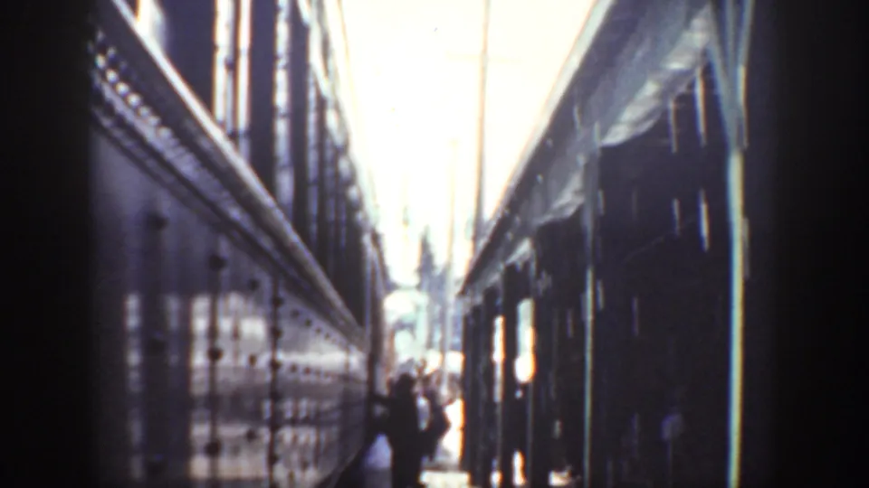 Washington 1940 frame showing glossy rail-car sides, strong daylight, and a person partly visible in the narrow passage.
