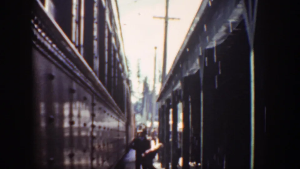 1940 Washington home-movie frame with a person near the opening between two dark structures, seen in soft focus.