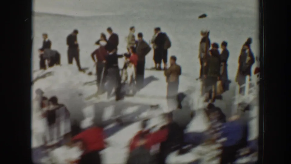 1940 Washington 8mm frame showing people in coats and hats standing and moving on snow, with outdoor gear nearby.