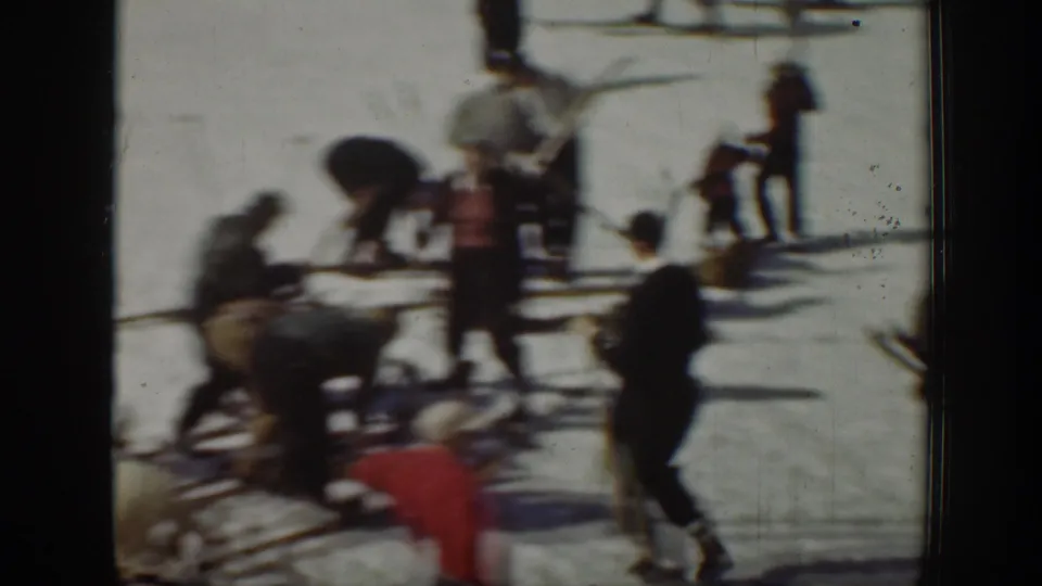 1940 Washington home-movie frame with blurred figures on snow around poles or equipment, suggesting winter activity.