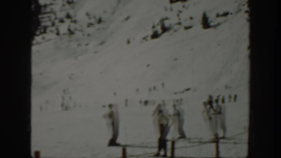 Washington 1940 home-movie frame of ski-area visitors standing in snow near a low fence.