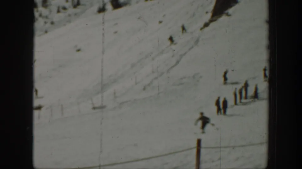 1940 Washington ski slope view with small figures descending or standing on the snow near a line of posts.