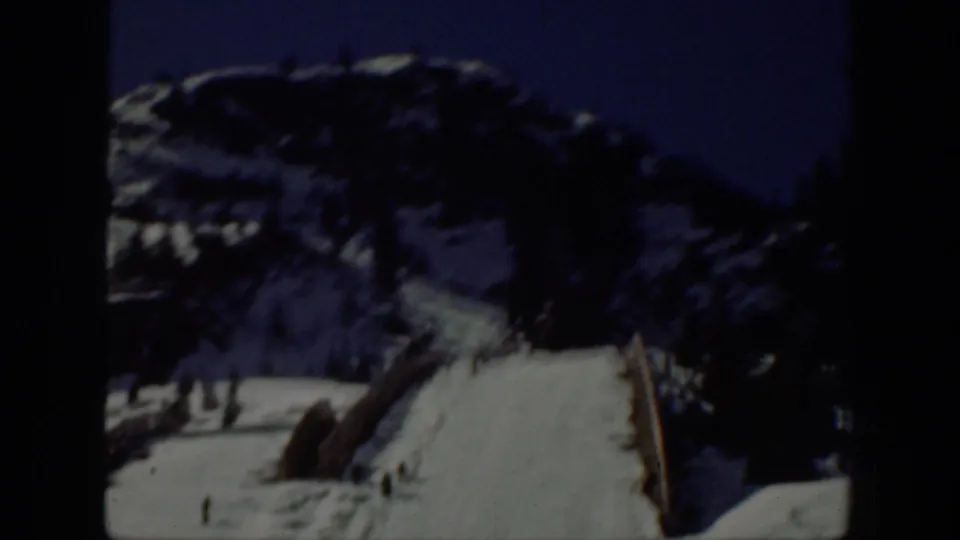 1940 Washington home-movie view of a snowy mountain ski run, dark terrain, and small skiers near the lower slope.