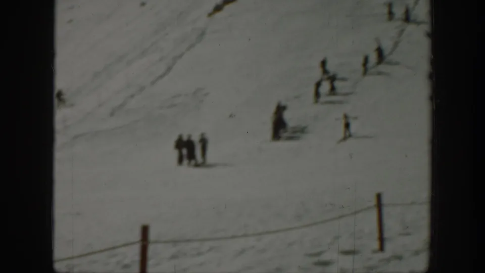 Small figures in winter clothing stand and move on a snowy Washington slope, filmed at a distance in 1940-era 8mm footage.
