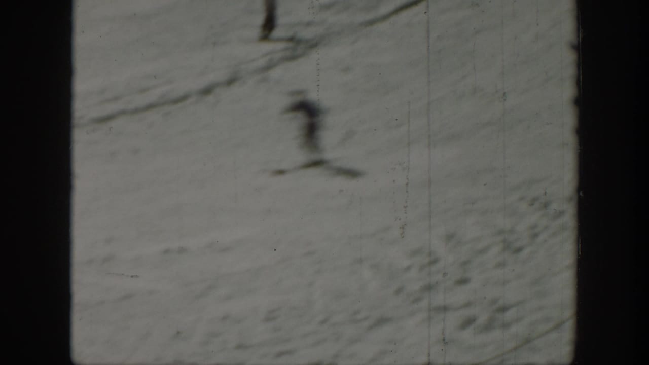 Blurred skier descending a snowy slope in a close view.