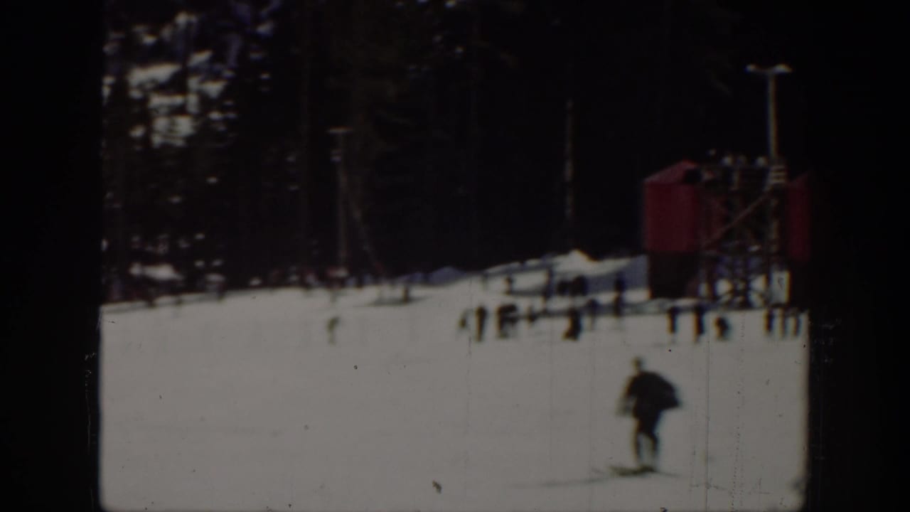 1940 Washington ski-area view with a skier in the foreground, scattered people, trees, and a small red structure in the background.