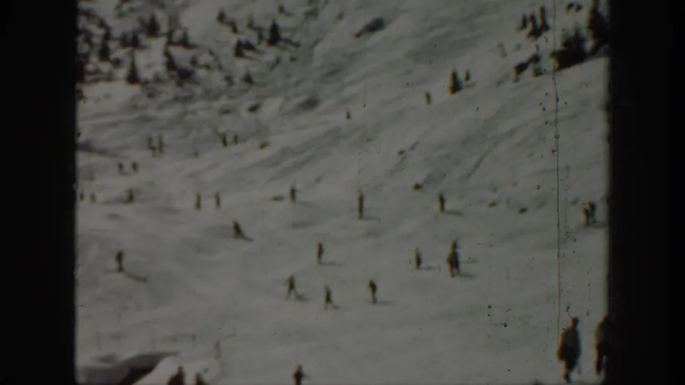 Home-movie frame from the 1940 Washington clip showing numerous skiers and visitors moving across a gently sloped snowy area.