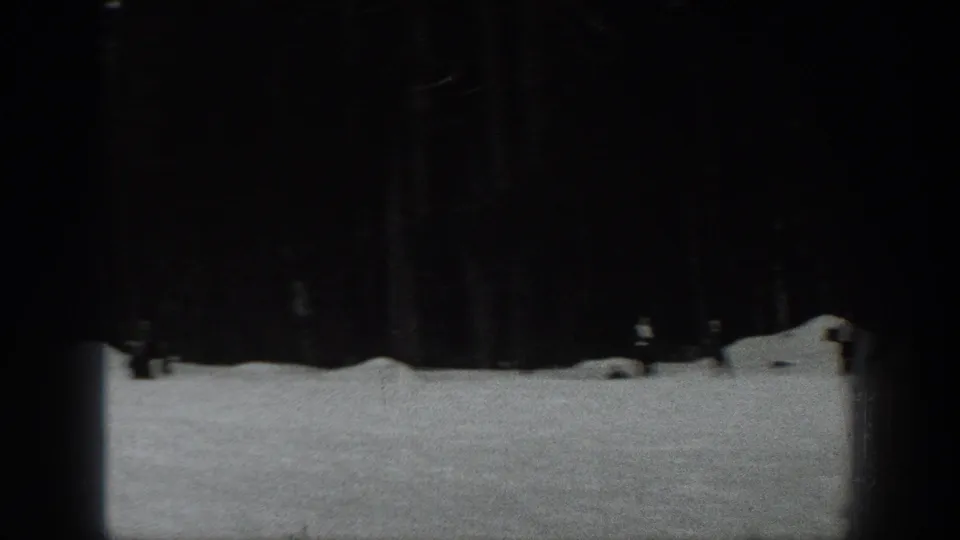 Black-and-white 1940 Washington frame showing open snow in front of dark evergreen trees, partly obscured by film exposure.