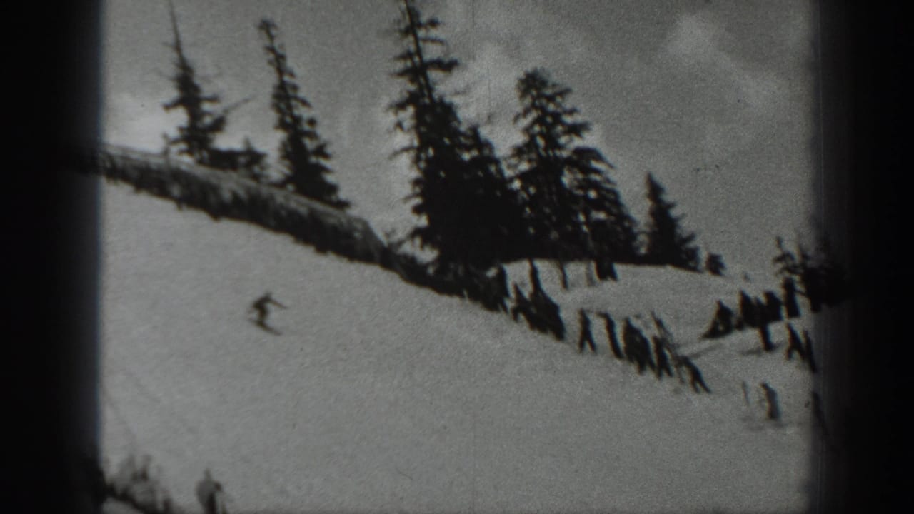 Black-and-white 8mm frame from Washington in 1940 with a skier on an open snowy slope and trees along the ridge.