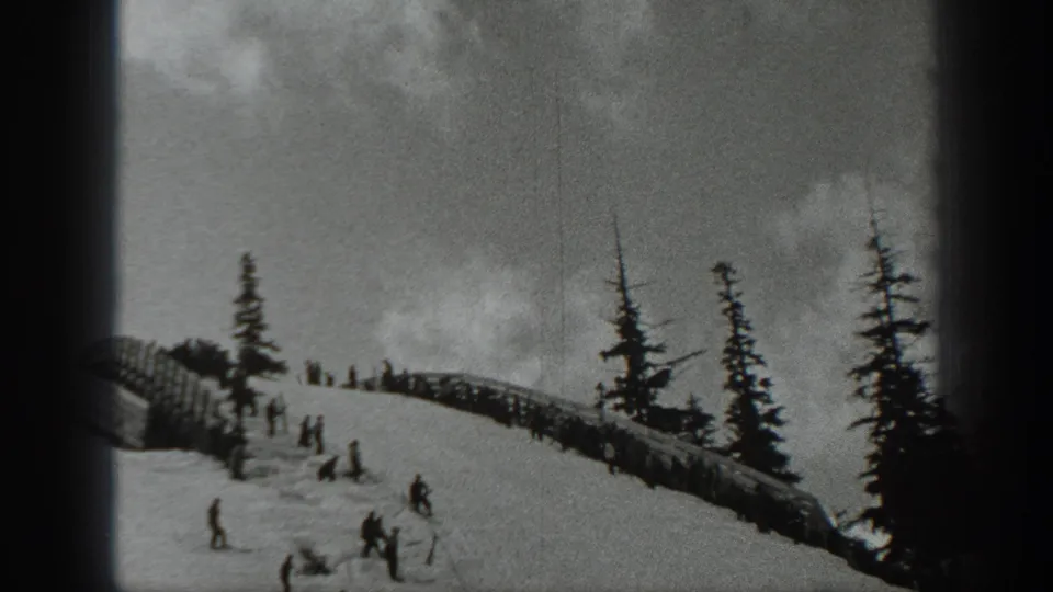 1940 Washington ski scene with several distant figures on a snowy slope, evergreen trees, and a low fence-like structure.