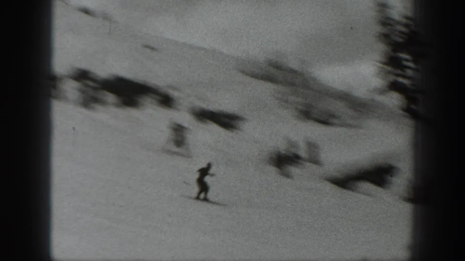 Soft 8mm frame from Washington in 1940 showing a skier on a snowy slope beneath a dark frame edge.