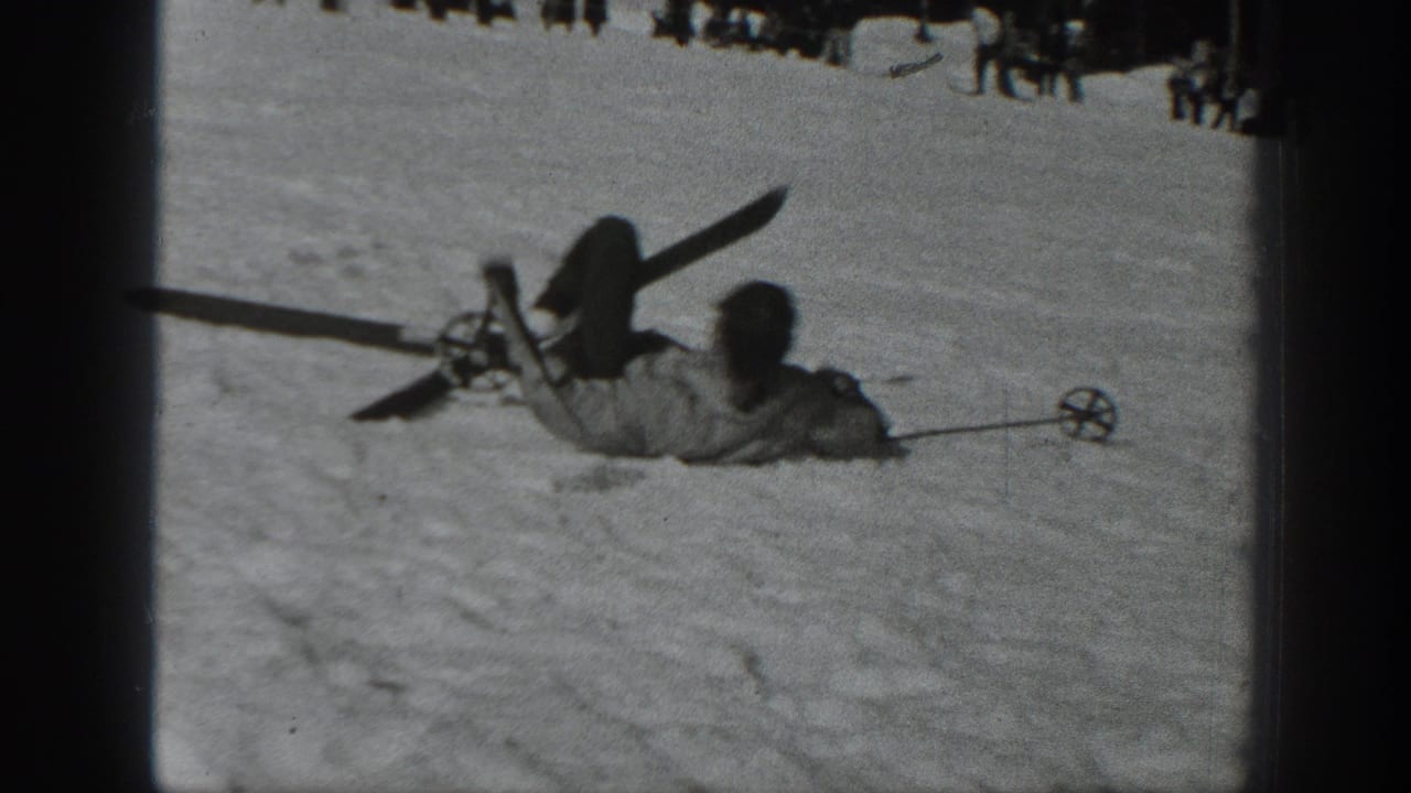 Fallen skier partly buried in snow with skis and poles visible.