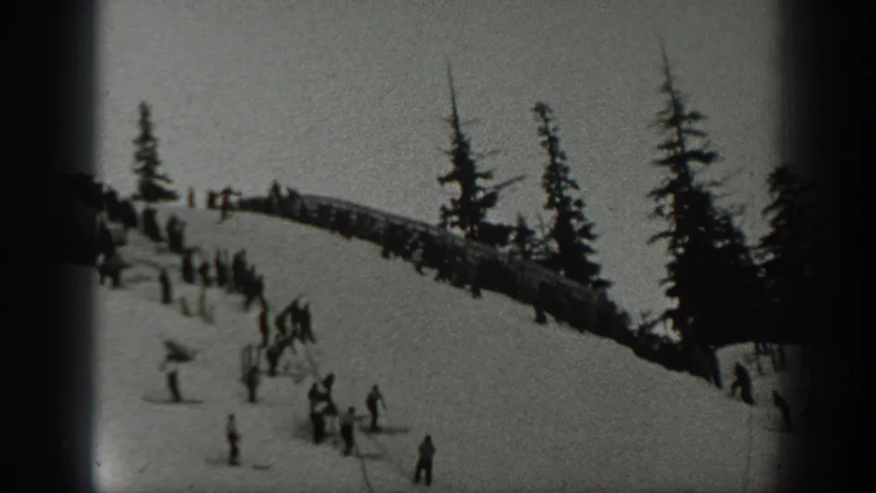 1940 Washington ski-slope scene with clustered skiers, tall pine trees, and a sloping snowfield seen through 8mm frame edges.