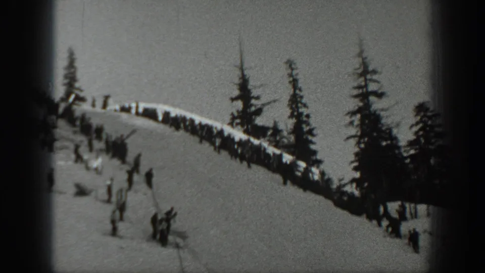 1940 Washington ski footage shows small figures on a snowy ridge with pine trees along the slope.