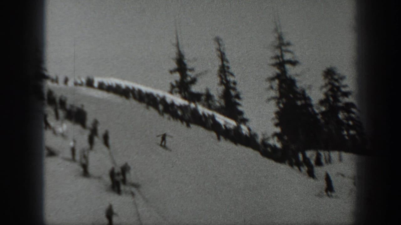1940 Washington home-movie frame showing skiers and spectators on a snowy mountain slope with dark evergreen trees.