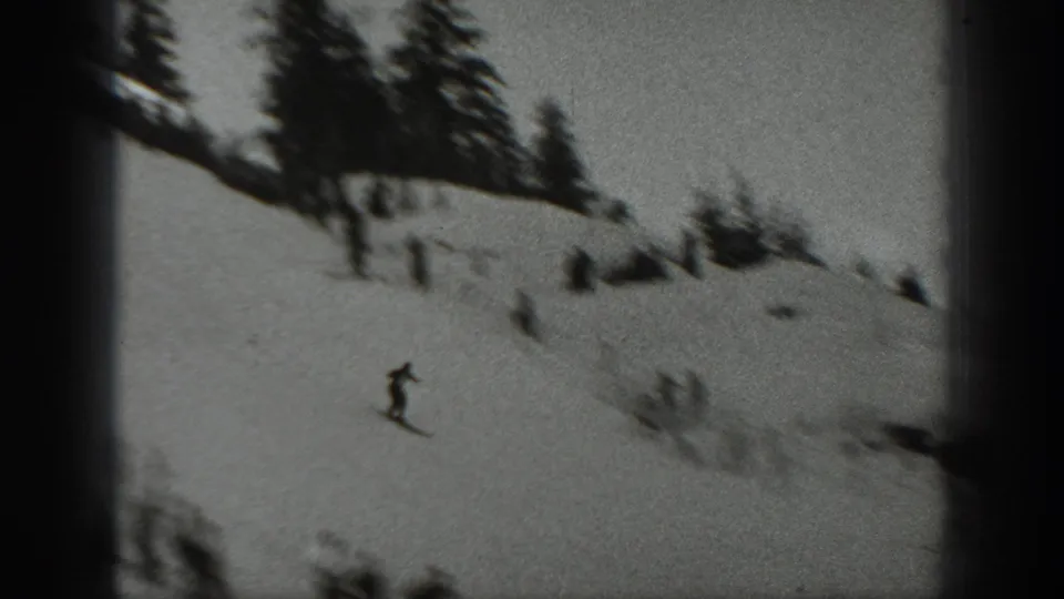 A 1940 Washington winter-sport figure moves across a snowy slope in soft-focus home-movie footage.