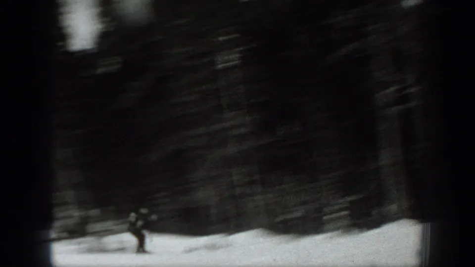 Final black-and-white frame shows a lone rider or skier against a dark blurred forest in Washington winter footage.