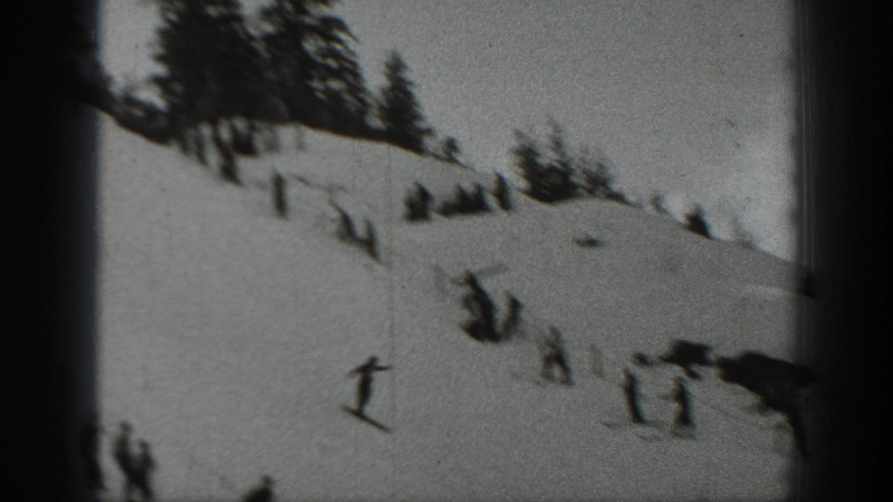 A distant skier crosses a snowy Washington slope while small spectator groups stand nearby in the 1940 home-movie frame.