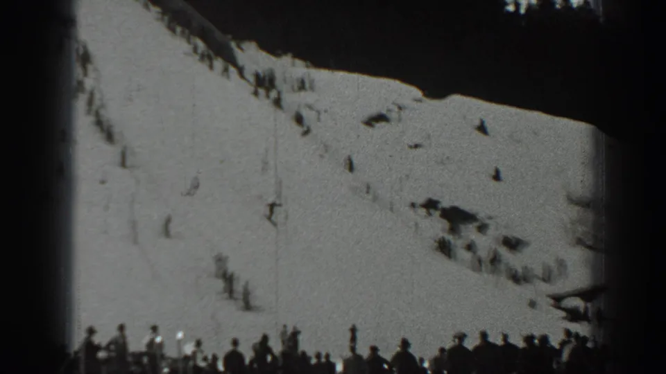 1940 Washington skiing scene with a crowd at the lower edge watching distant skiers on a broad snowy hillside.