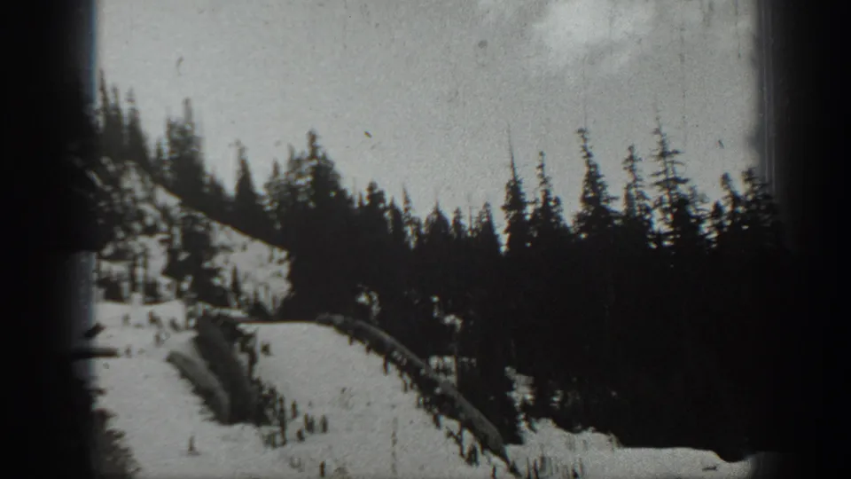 1940 Washington ski-area view of a snowy hillside run cutting through dark evergreen forest.