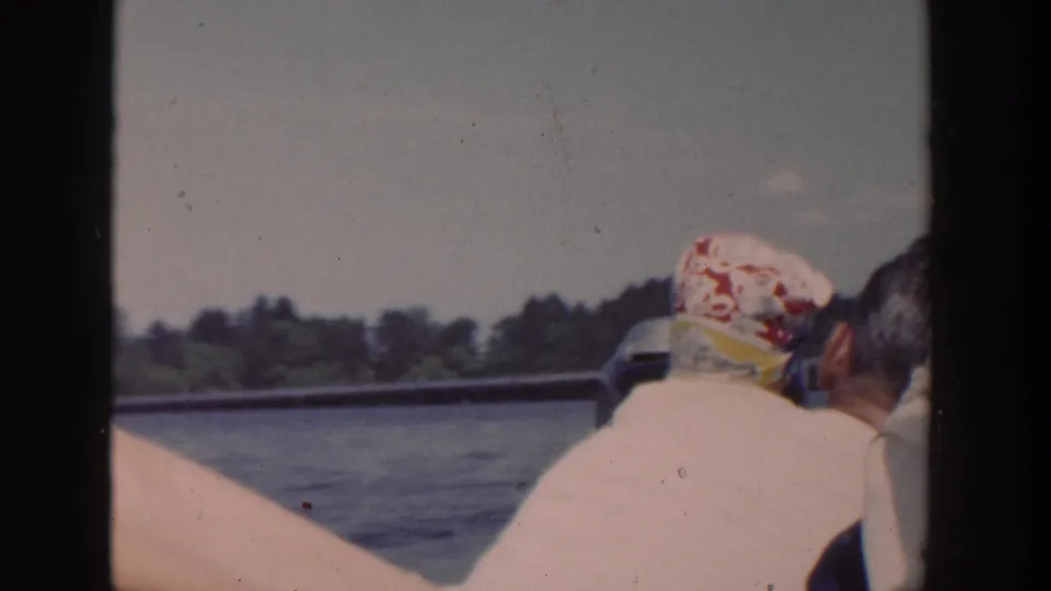 1953 Wisconsin home-movie frame from a boat, with an adult and baby seen from behind near the rail.