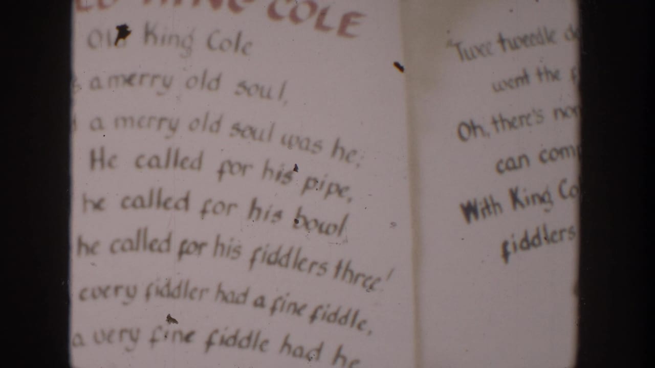 1954 Wisconsin Dells home-movie frame showing a hand-lettered Old King Cole rhyme page with dark vertical frame edges.
