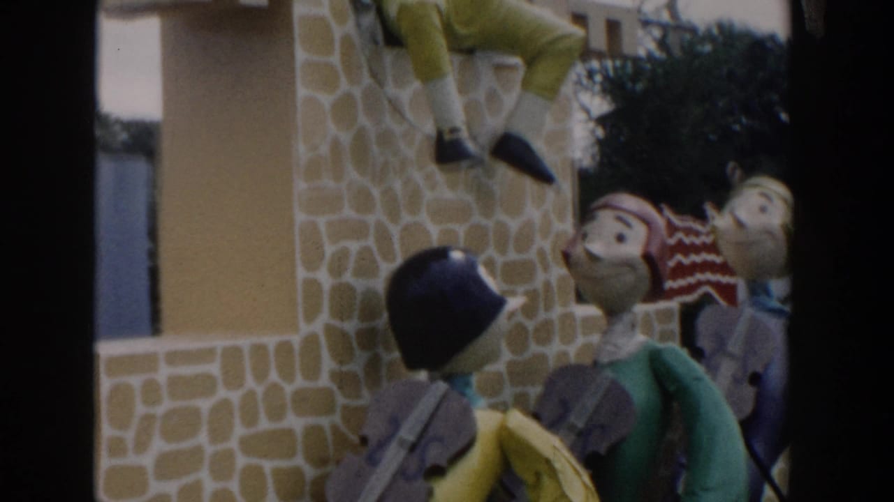 1954 Wisconsin Dells home-movie frame showing colorful oversized figures near a stone-textured amusement-park facade.