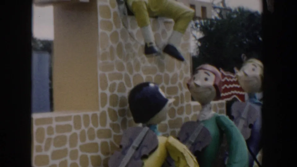 1954 Wisconsin Dells home-movie frame showing colorful oversized figures near a stone-textured amusement-park facade.