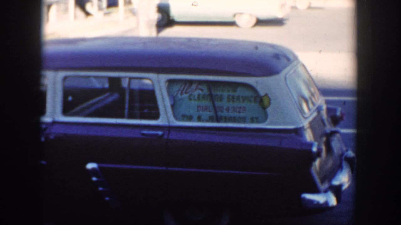 Side view of the parked wagon with window lettering and cars in the background.