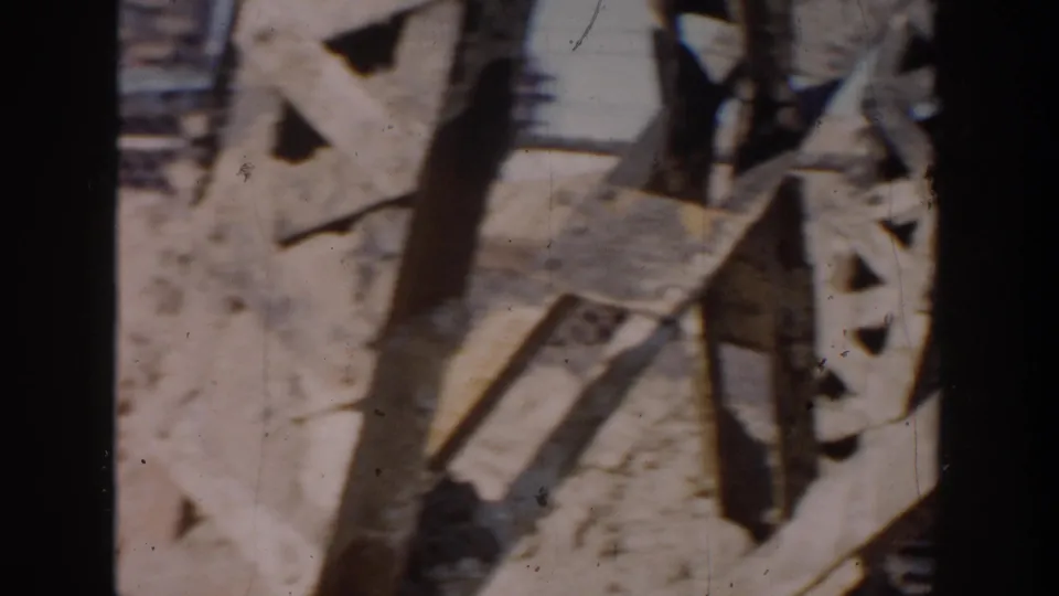 Close, soft 8mm view of scattered boards or barrier fragments at the Grand Rapids construction site.