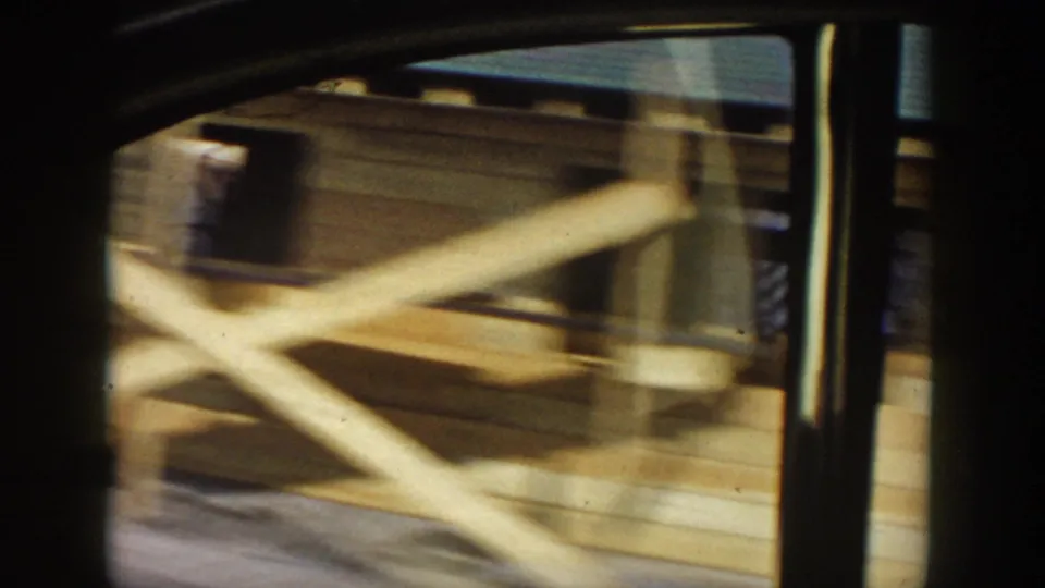 Moving 8mm view of pale wooden construction forms or railings near the vehicle window in Grand Rapids, Michigan.
