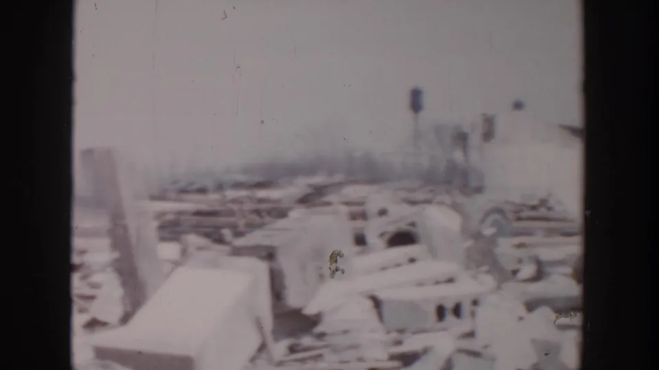 Grand Rapids storm aftermath showing snow-covered marina debris, damaged boats, and broken dock materials along frozen water.