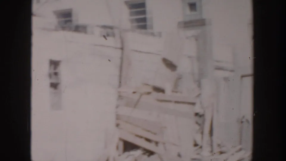 Home-movie view of older Grand Rapids house exteriors, windows and yard structures in soft faded 8mm color.