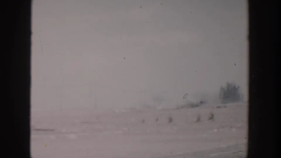 A hazy roadside view in 1956 Grand Rapids-area home-movie footage, with soft focus and visible film gate edges.