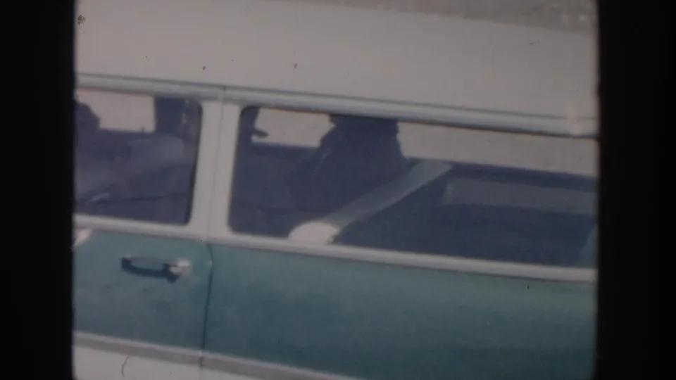 A green and white station wagon moves through the frame in 1956 Grand Rapids-area home-movie footage.