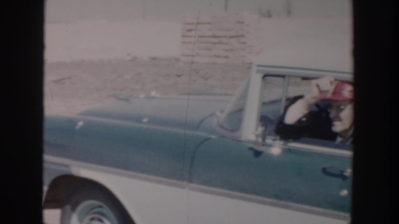 Side view of the sedan with the man still visible through the window.