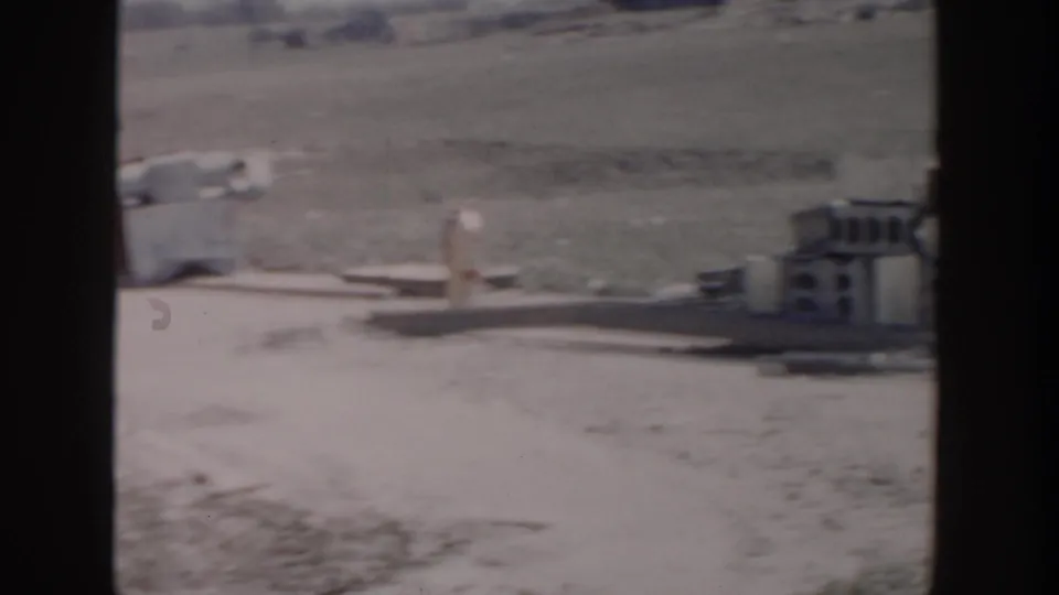Soft 8mm frame from the Grand Rapids construction site showing blocks, pipes, debris, and open ground.