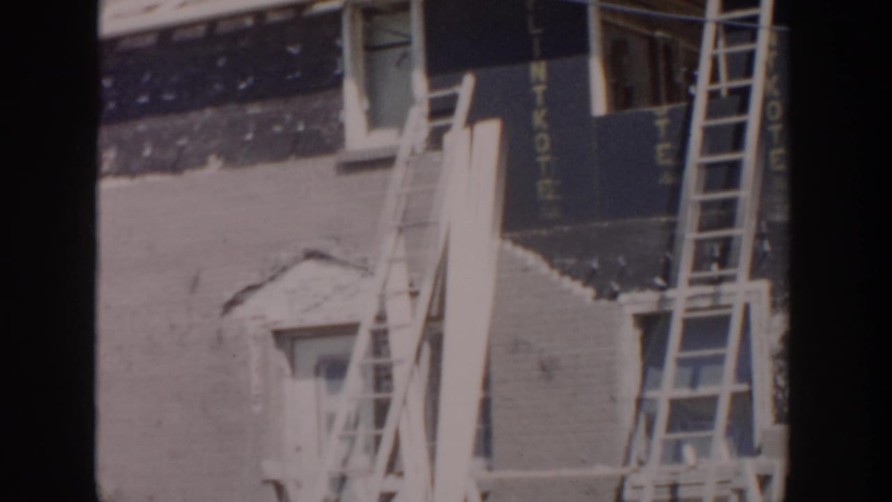 Ladders lean against an unfinished house exterior during construction.