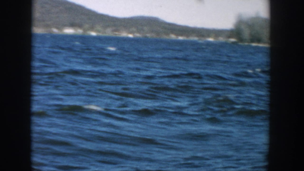 Blue lake water with a low hilly shoreline visible across the horizon.
