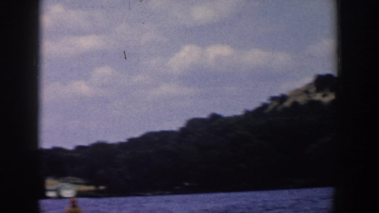 Forested shoreline and lake fill the frame, with the skier partly low in view.