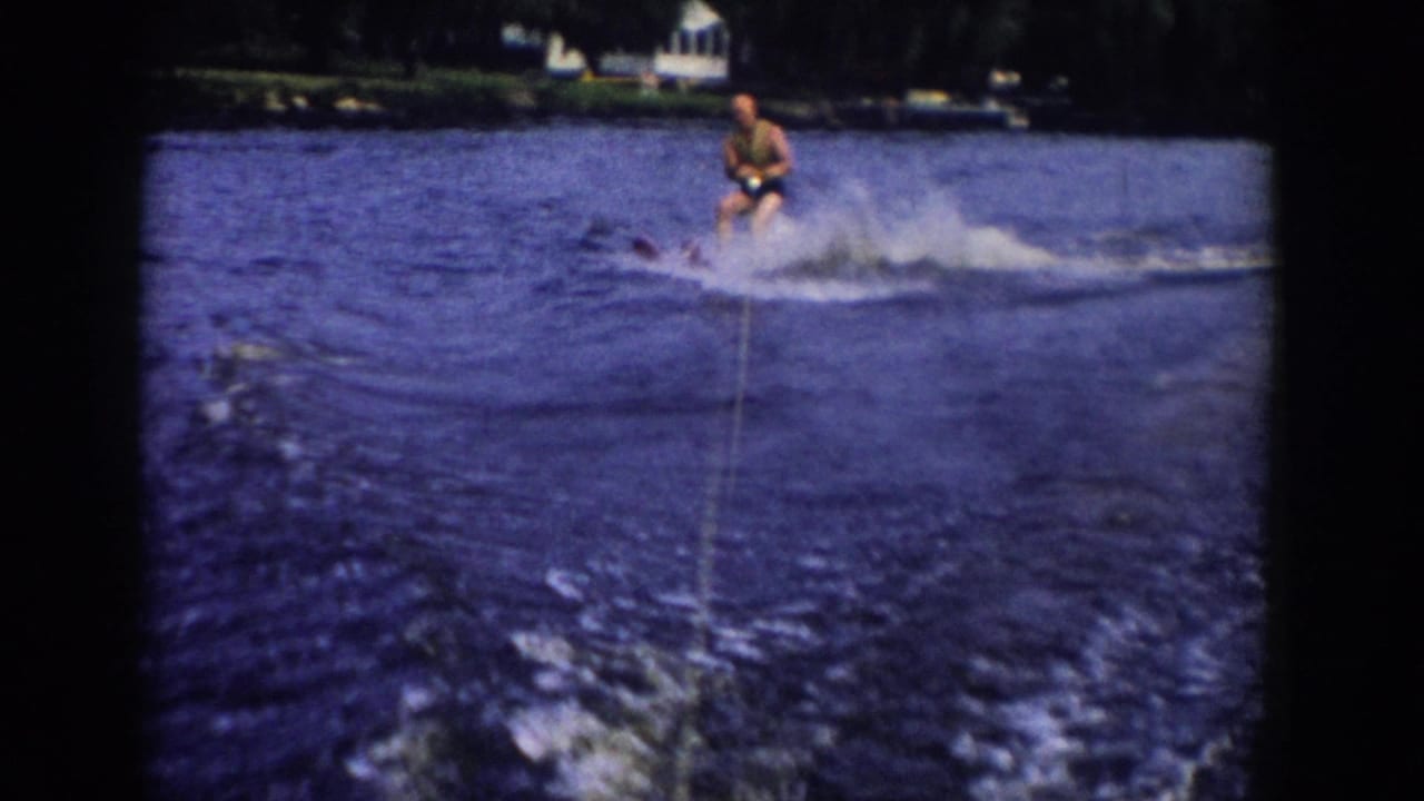 The skier moves across the lake wake in 1958 Wisconsin footage, with the tow rope leading back toward the filming boat.