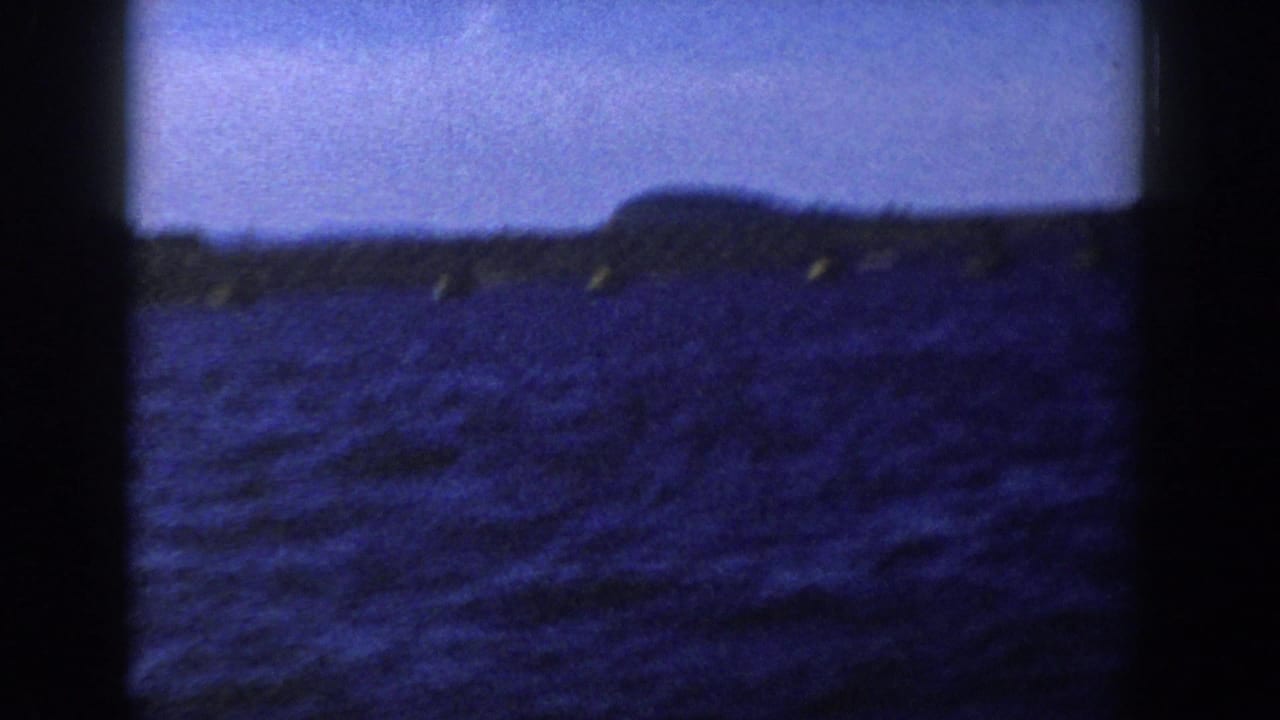 Open water with distant shoreline and small yellow buoys near the horizon.