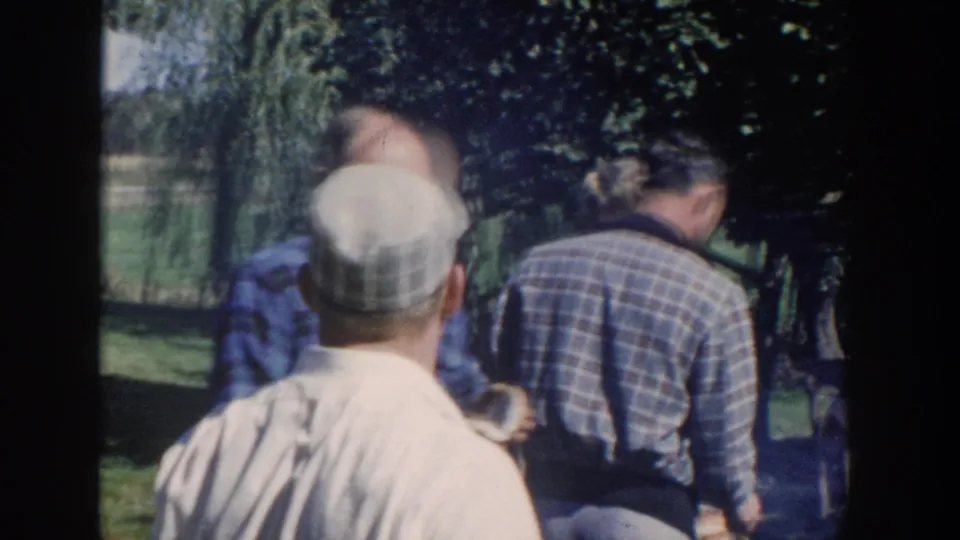 The final frame shows adults from behind in a leafy Wisconsin yard, continuing the outdoor barbecue gathering.
