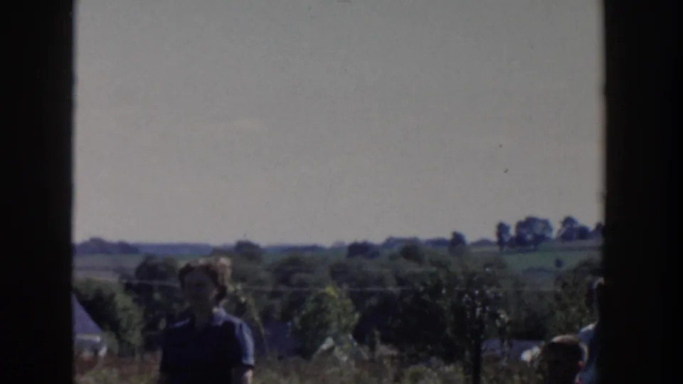1958 Wisconsin countryside with rolling fields and trees, with a partially visible person near the lower foreground.